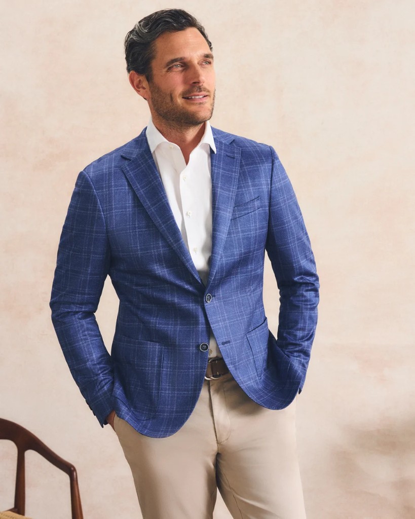 Man in a blue plaid sport coat, white shirt, and khaki trousers